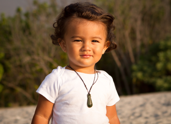 Māori toddler outside with pounamu necklace Canva