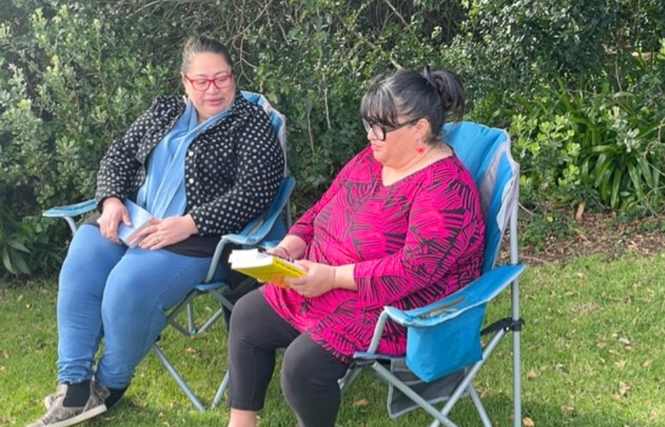 2 friends outside in garden reading books HNCT resized